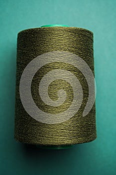 Green thread spool background, close-up