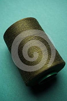 Green thread spool background, close-up