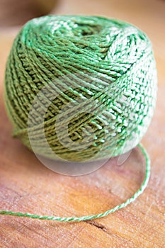 Green thread spool on wood