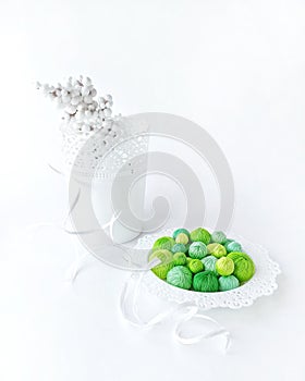 Green threads in a white basket on a white background.