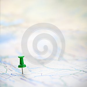 Green thumbtack marking and showing destination location point on map background with copy space