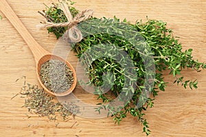 Green thyme bunch with dried thyme seeds on wooden background. top view