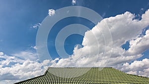 Green tile roof on a new house with blue sky