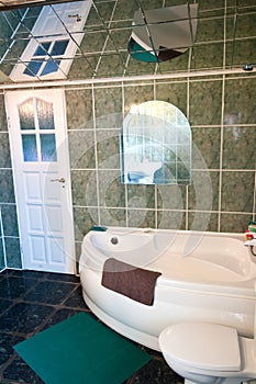 Green tiled bathroom with mirror ceiling