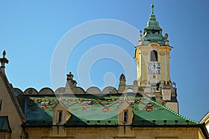 Green tiled roof with town hall clock tower behind Bratislava, Slovakia