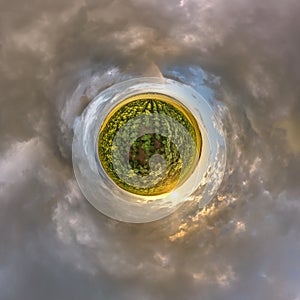 green tiny planet in blue sky with beautiful evening clouds with sunflowers with transformation of spherical panorama 360 degrees