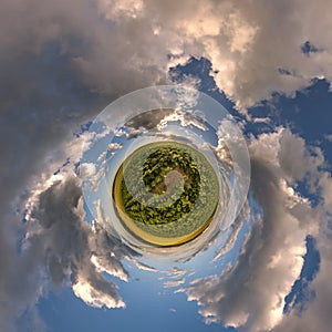 green tiny planet in blue sky with beautiful evening clouds with sunflowers with transformation of spherical panorama 360 degrees