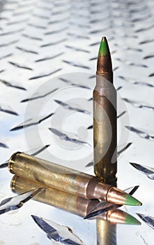 Green tipped rifle shells on chrome metal