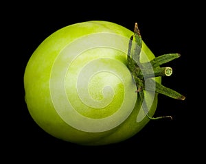 Green tomato isolated on a black background