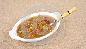 Green tomato piccalilli in dish with spoon