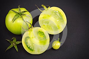Green tomatoes on dark backgeround photo