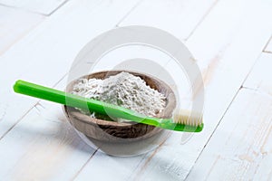 Green toothbrush and ecological baking soda salt in wooden cup