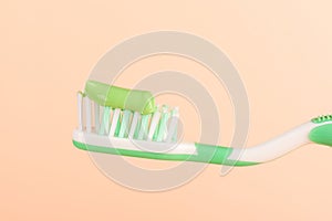 Green toothpaste on a toothbrush with space for text.