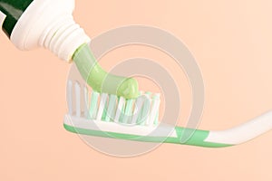 Green toothpaste from the tube onto the toothbrush.