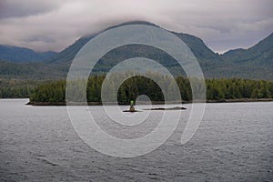 Green top on nautical navigation marker under cloudy sky in Alaska\'s inside passage