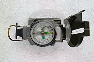 Green tourist compass located horizontally on a light background