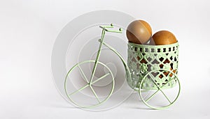 Green toy bike with colored eggs in basket