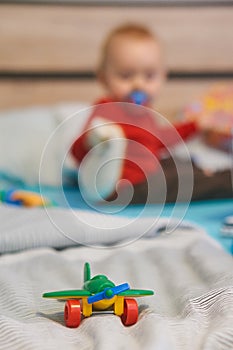 Green toy plane on bed.