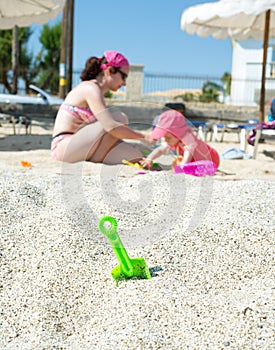 Green toy spade in the sand