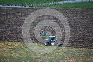 Green Tractor Plowing Through Agricultural Fields