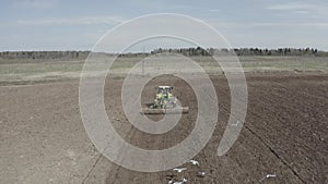 Green tractor plows a field