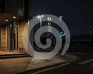 Green traffic light at the crossroads of a city street in the dark at night