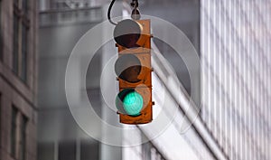 Green traffic lights for cars, blur office buildings background