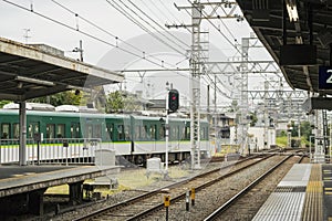 Green train enters local station in Kyoto,