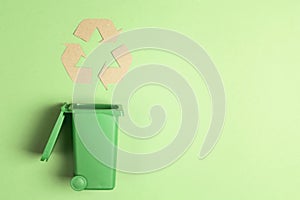 Green trash bin with recycling symbol