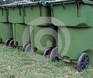 Green trash bins, recycling trash cans on grass