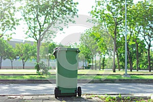 Green trash in the garden. Moulded plastic, wheeled waste bin in The park. Trash or bin is tools of Waste management. photo