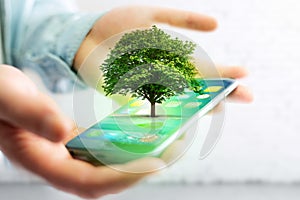 Green tree going out of a smartphone - Ecology concept