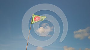 Green triangle flag with red dot indicating a surfing area, blue sky, in France