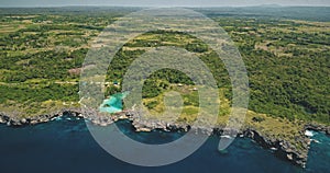 Green tropic forest at cliff sea bay with turquoise salt water lake aerial view. Epic nature scenery