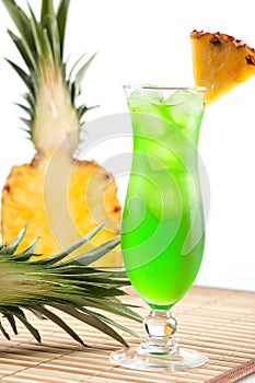 Green tropical cocktail with pineapple slice