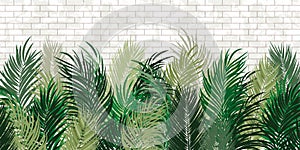 Green tropical leaves on the white brick wall background. Old bricks with texture, green exotic palm leaves.