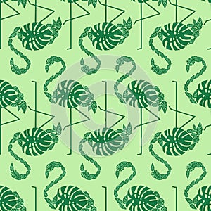 Green tropical trendy seamless pattern with decorative flamingos from palm leaves.