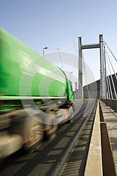 Green Truck In Motion on a cable-stayed bridge photo