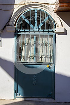 A green Turkish-style metal door with a white wall
