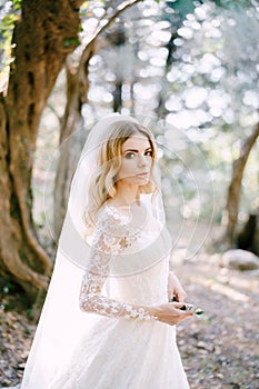 Green twig in the hands of the bride in a white embroidered dress