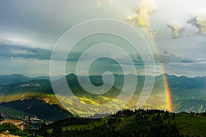 Green tyrol alm alps nature landscape in Austria at summer after storm with rainbow