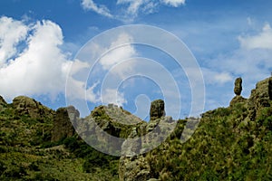 Green valley and rock formations under blue sky