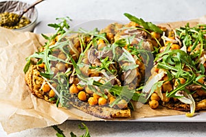 Green vegan pizza with pesto, chickpeas, champignons and arugula