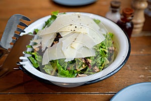 Green vegetable salad with parmesan cheese toppings in a bowl