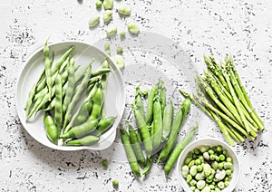 Green vegetables - asparagus, green beans and peas on a light background