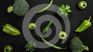 Green vegetables: broccoli, peppers, tomatoes and cucumbers arranged on rustic wooden table