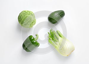 Green vegetables and fruit on white background