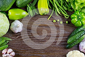 Green vegetables harvest, raw healthy organic food on wooden background