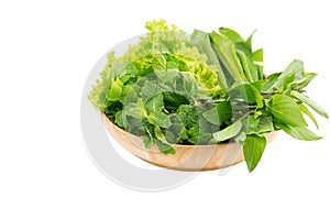 Green vegetables in wooden plate on white isolated background