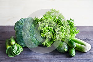 Green vegetables on a wooden table. Salad, broccoli, spinach, ce